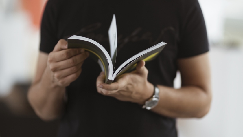 Hombre sujetando un libro. / Magnific